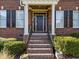 Inviting entrance with brick steps and columns, framed by manicured bushes and windows at 5016 Dillswood Ln, Raleigh, NC 27606