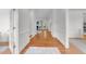 Long hallway featuring hardwood floors, bright white walls, and access to multiple rooms at 5016 Dillswood Ln, Raleigh, NC 27606
