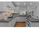 Well-lit kitchen featuring white cabinets, granite countertops, stainless steel appliances and hardwood floors at 5016 Dillswood Ln, Raleigh, NC 27606
