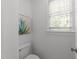 Powder room featuring a toilet, window, and modern art at 5016 Dillswood Ln, Raleigh, NC 27606
