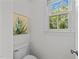 Well-lit powder room features a white toilet, window and painting at 5016 Dillswood Ln, Raleigh, NC 27606