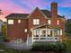 Brick home featuring a screened porch and stone patio, perfect for outdoor entertaining at 5016 Dillswood Ln, Raleigh, NC 27606