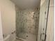 Modern shower with marble tile surround and glass door at 5016 Dillswood Ln, Raleigh, NC 27606