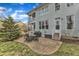 Two story back exterior view with a textured concrete patio area, table, grill, and backyard at 5109 Dove Forest Ln, Apex, NC 27539