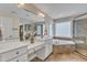 Bright bathroom with double vanity, large mirror, soaking tub, and separate shower, plus a view to the walk-in closet at 5109 Dove Forest Ln, Apex, NC 27539