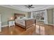A spacious bedroom with a large bed, hardwood floors, ceiling fan, and a large window providing natural light at 5109 Dove Forest Ln, Apex, NC 27539