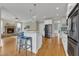 Open kitchen view featuring stone fireplace in living room and hardwood floors at 5109 Dove Forest Ln, Apex, NC 27539