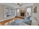 Sun-filled living room features stone fireplace, hardwood floors, and access to sunroom at 5109 Dove Forest Ln, Apex, NC 27539