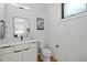 Modern half bath with a white vanity, wall mirror, toilet and fixtures at 512 Edgecreek Ct, Raleigh, NC 27604