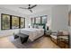 Bright main bedroom with large windows, hardwood floors, and a modern ceiling fan at 512 Edgecreek Ct, Raleigh, NC 27604