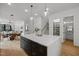 Open kitchen layout with large island and stainless appliances flows into dining and living areas at 513 Edgecreek Ct, Raleigh, NC 27604