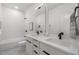 Modern bathroom with double vanity, sleek fixtures, and bathtub with tiled surround at 515 Edgecreek Ct, Raleigh, NC 27604