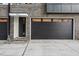 Modern townhome exterior featuring a black garage door, gray brick, and stylish entry door for a contemporary appeal at 517 Edgecreek Ct, Raleigh, NC 27604
