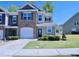 Charming two-story townhome with a brick and siding facade, attached garage, and manicured lawn at 547 Historic Dr, Hillsborough, NC 27278