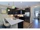 Modern kitchen with sleek black cabinets, stainless steel appliances, quartz countertops, and barstool seating at 547 Historic Dr, Hillsborough, NC 27278