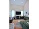 Bright living room features a fireplace, a large TV, and a comfortable, oversized green sectional sofa at 547 Historic Dr, Hillsborough, NC 27278