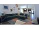 Comfortable living room with a plush green sectional, stylish rug, and a glimpse of the modern kitchen at 547 Historic Dr, Hillsborough, NC 27278