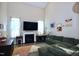 Spacious living room with high ceilings, a cozy fireplace, large TV and ample seating on a large green couch at 547 Historic Dr, Hillsborough, NC 27278