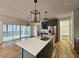 Open kitchen featuring gray cabinets, stainless steel appliances, hardwood floors, and an island with a sink at 5491 Silk Hope Gum Springs Rd, Siler City, NC 27344