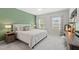 Bright bedroom with a green accent wall, plush carpeting, and ample natural light at 594 Historic Dr, Hillsborough, NC 27278