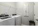 Bright laundry room with white washer, dryer, and shelving for optimal organization at 594 Historic Dr, Hillsborough, NC 27278
