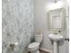 Charming powder room with stylish wallpaper, pedestal sink, and modern fixtures at 594 Historic Dr, Hillsborough, NC 27278