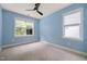 Light blue bedroom with neutral carpet and a view of the outdoors through two windows at 607 Millbrook Dr, Pittsboro, NC 27312