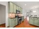 Kitchen featuring stainless steel oven, microwave and sage green cabinets at 607 Millbrook Dr, Pittsboro, NC 27312