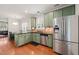 Bright kitchen with stainless steel appliances, green cabinets, and granite countertops at 607 Millbrook Dr, Pittsboro, NC 27312