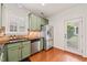 Modern kitchen with stainless steel appliances, green cabinets, an exterior door, and hardwood floors at 607 Millbrook Dr, Pittsboro, NC 27312