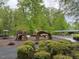 Community playground surrounded by trees, walking path, and a covered seating area at 607 Millbrook Dr, Pittsboro, NC 27312