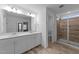 Stylish bathroom with double vanity, quartz countertop, and glass-enclosed shower, blending beauty and practicality at 608 Creekway Dr, Fuquay Varina, NC 27526