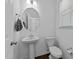 Neat half bathroom with a pedestal sink, round mirror and a toilet, offering a clean and simple design at 608 Creekway Dr, Fuquay Varina, NC 27526