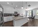 Modern kitchen featuring white cabinets, a granite island, stainless steel appliances, and an eat-in breakfast area at 608 Creekway Dr, Fuquay Varina, NC 27526