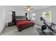Cozy main bedroom with a large bed, bedside tables and exercise bike, illuminated by natural light at 608 Creekway Dr, Fuquay Varina, NC 27526