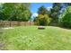 Large grassy yard with wooden fence, fire pit and trees to offer privacy and shade for outdoor living at 611 Edenberry Dr, Durham, NC 27713