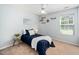 Charming bedroom with a large window, modern ceiling fan, and blue decor, perfect for a guest room at 611 Edenberry Dr, Durham, NC 27713