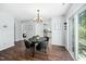 Cozy dining area with a modern chandelier, view of the backyard and an adjacent white kitchen at 611 Edenberry Dr, Durham, NC 27713