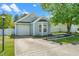 Attractive single-story home with light blue siding, attached garage, and concrete driveway at 611 Edenberry Dr, Durham, NC 27713