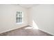 Bright bedroom features neutral walls, carpet flooring, and a window with natural light at 614 Canyon Lake Cir, Morrisville, NC 27560