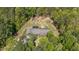 Stunning aerial view of house surrounded by lush trees, fenced yard, and solar panels at 626 Bailey Rd, Coats, NC 27521
