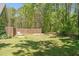 A large backyard with grass, garden boxes, and wooden fence bordering a wooded area at 626 Bailey Rd, Coats, NC 27521