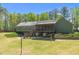 Spacious, well-kept backyard featuring a screened-in porch, volleyball net and green lawn at 626 Bailey Rd, Coats, NC 27521