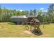 A lush green yard with playset, and a beautiful home with solar panels and screened-in porch at 626 Bailey Rd, Coats, NC 27521