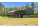 View of the home's screened-in porch, leading to a expansive backyard and volleyball net at 626 Bailey Rd, Coats, NC 27521