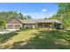 Backyard featuring a lush green lawn and an inviting covered porch with wooden beams at 626 Bailey Rd, Coats, NC 27521