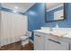 Vibrant bathroom featuring a modern sink and white vanity with a blue wall and a shower at 626 Bailey Rd, Coats, NC 27521