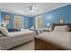 Inviting bedroom featuring three twin beds, natural light, and blue painted walls at 626 Bailey Rd, Coats, NC 27521
