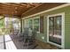Charming front porch with a porch swing, rocking chairs, and green siding at 626 Bailey Rd, Coats, NC 27521