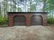 Two-car garage with metal siding and roll-up doors, set amongst trees at 626 Bailey Rd, Coats, NC 27521